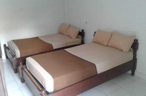 two beds sitting next to each other in a room at Hotel Diana 1 in Denpasar