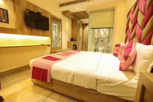 a bedroom with a large bed and a television at Hotel Golden Lotus in Amritsar