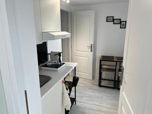 - une petite cuisine blanche avec un évier et un comptoir dans l'établissement AZZA Residence, à Bucarest
