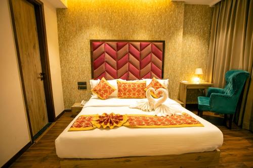 a hotel room with a bed with two swans on it at Hotel Golden Lotus in Amritsar