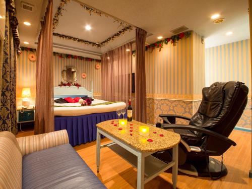 神戸市にあるホテルギャラリー（大人専用）のベッド、テーブル、椅子が備わる客室です。