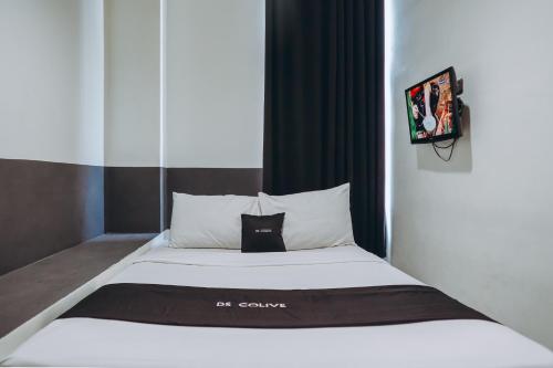 un letto con lenzuola e cuscini bianchi e neri di DS Colive Peterongan a Jomblang