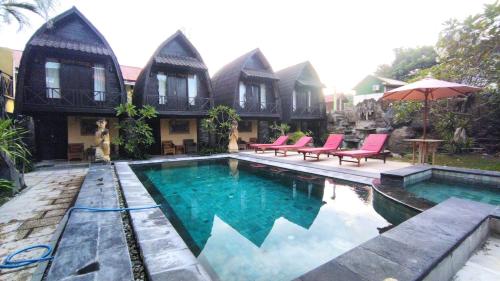 a villa with a swimming pool in front of a house at Bale Sasak Bungalow in Gili Trawangan