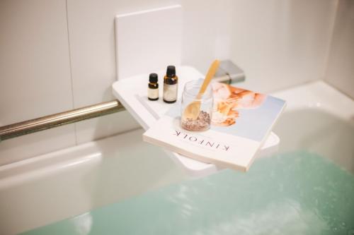 a bathroom counter with a mommy box and bottles on it at Twin-Line Hotel Karuizawa Japan in Karuizawa