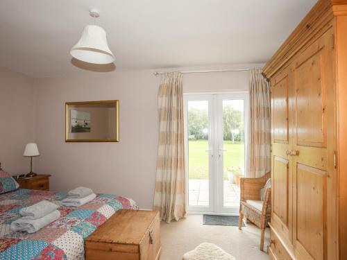 a bedroom with a bed and a sliding glass door at Machlud Ynys in Y Felinheli