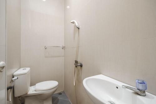 a bathroom with a toilet and a sink and a shower at RedDoorz Syariah near Universitas Bengkulu in Bengkulu