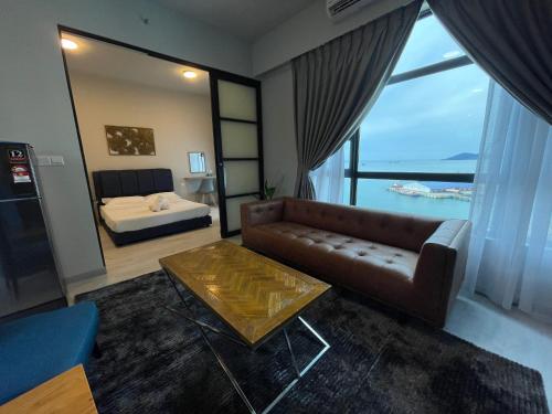 een woonkamer met een bank en een bed bij SEAVIEW LUXURY CONDO HOMESTAY 2Bed 2bath Jesselton Quay by R2 Residence in Kota Kinabalu