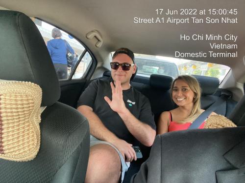 un homme et une femme assis à l'arrière d'une voiture dans l'établissement Ha Noi Hotel near Tan Son Nhat International Airport, à Hô-Chi-Minh-Ville
