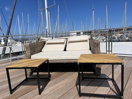 a bed on the deck of a boat with two tables at Floating Home Nr 1a in Laboe