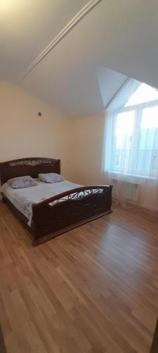 uma cama num quarto com piso em madeira em Garni family house B&B em Garni