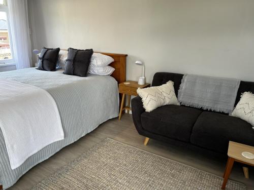 a living room with a bed and a couch at Raglan Retreat on Gilmour in Raglan