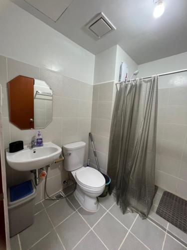 uma casa de banho com um WC, um lavatório e um chuveiro em Cozy condo in Bacolod City em Bacolod