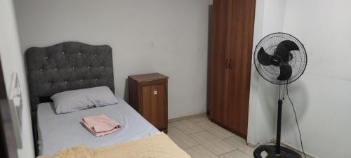 a small bedroom with a bed and a fan at Midtown Hotel Apartments 305 (0+1) in Istanbul