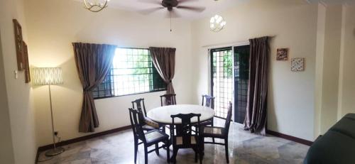- une salle à manger avec une table, des chaises et des fenêtres dans l'établissement PD Villa 12 Homestay, à Port Dickson