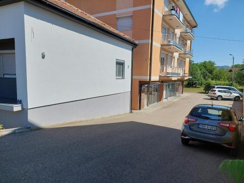 een auto geparkeerd op een parkeerplaats naast een gebouw bij Aleksandar in Banja Luka