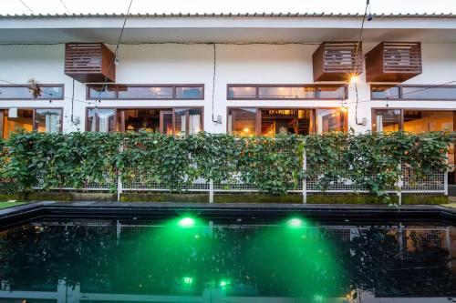 een gebouw met een zwembad voor een gebouw met groene lichten bij Old Style Surf Apartment with Private Kitchen and Shared Pool Canggu in Canggu