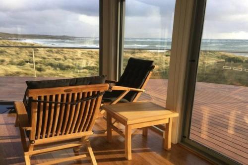 a room with two chairs and a table and a window at Wave Retreat, King Island in Loorana