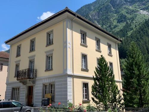un grand bâtiment en face d'une montagne dans l'établissement Casa Restelli EG - nahe Andermatt Gotthard, à Gurtnellen
