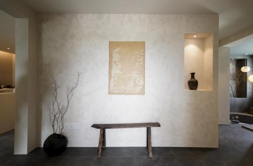 a bench against a wall with a picture and a vase at Haru YeonGa in Gyeongju