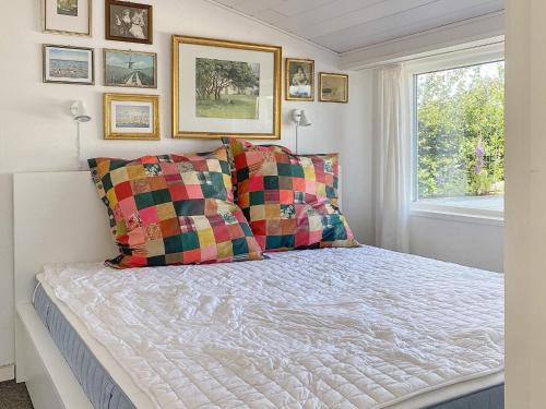 a bedroom with a bed with two pillows and a window at Holiday home Aabenraa LXIII in Aabenraa