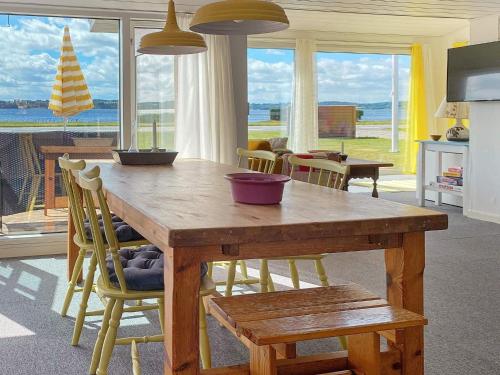 eine Küche mit einem Holztisch und Stühlen mit Meerblick in der Unterkunft Holiday home Aabenraa LXIII in Aabenraa