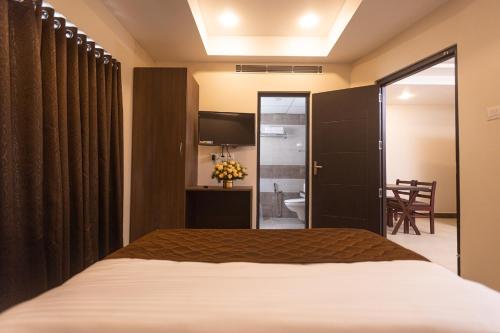 une chambre d'hôtel avec un lit et une télévision dans l'établissement HOTEL PANKAJ RESIDENCY, à Guruvāyūr