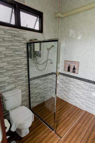 a bathroom with a shower and a toilet at Baan chomphu @Pua in Pua