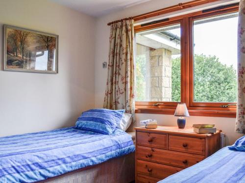 a bedroom with two beds and a window at Coille Mhor in Clunie