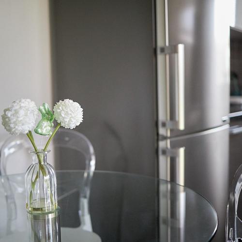 a glass vase with flowers in it on a table at Klaudia Vendégház in Mórahalom