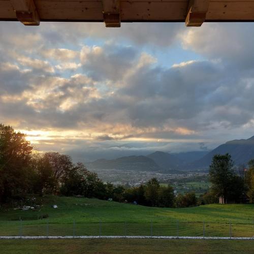 a view of a field with mountains in the background at La casa di Maia - Alloggio Agrituristico in Pedavena