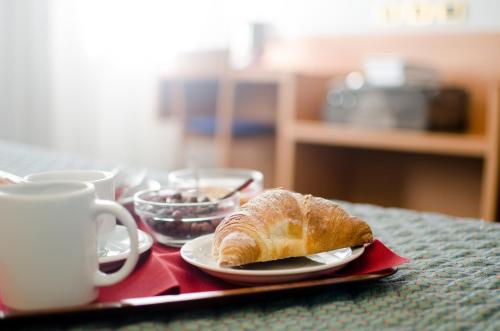 a table with a plate of bread and a cup of coffee at Hotel Residence Club Primula in Pescasseroli
