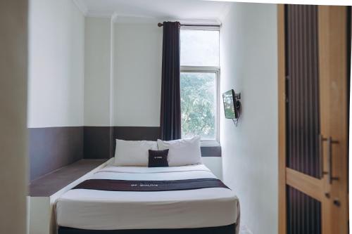 a small bed in a room with a window at DS Colive Layur Kota Lama in Semarang