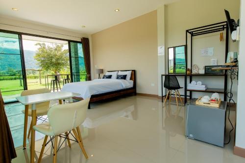 a bedroom with a bed and a table and chairs at Baan chomphu @Pua in Pua