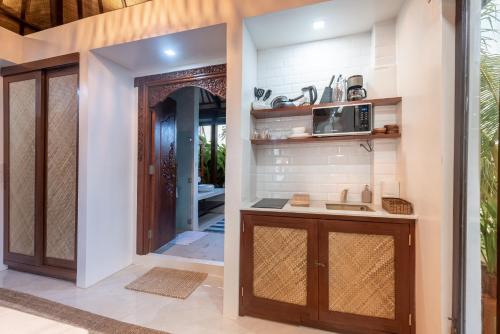 una cocina con fregadero y microondas junto a una puerta en VILLA JUAN - A Beach Front Villa in General Luna Siargao en General Luna