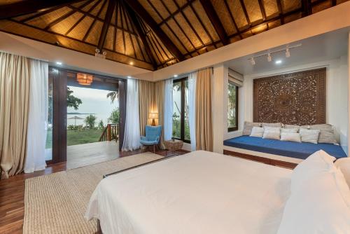 a bedroom with a large bed and a large window at VILLA JUAN - A Beach Front Villa in General Luna Siargao in General Luna