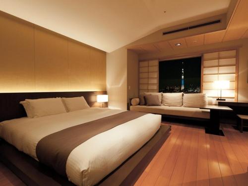 a bedroom with a bed and a desk and a window at Hotel East 21 Tokyo in Tokyo