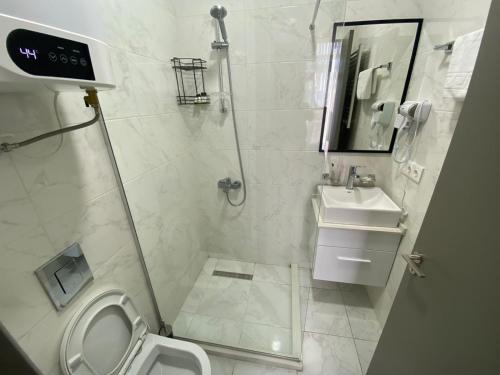 a bathroom with a shower and a toilet and a sink at boulevard apartments in Batumi