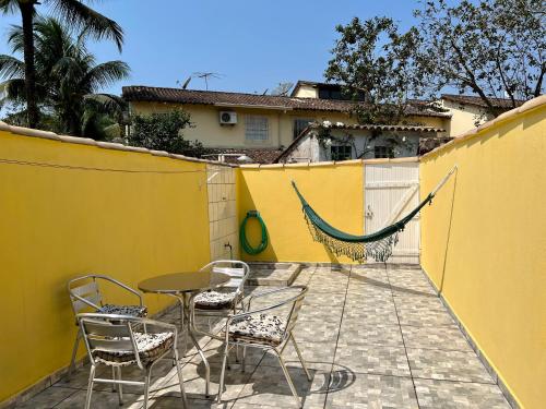 d'une terrasse avec des chaises, une table et une clôture. dans l'établissement Casa verde no centro de Paraty, à Parati