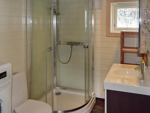 a bathroom with a shower and a toilet and a sink at Holiday home Aseral II in Tjaldal
