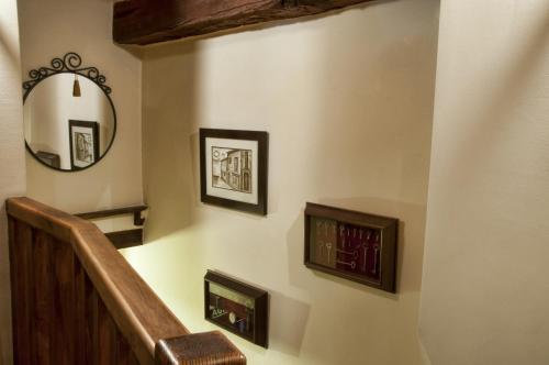 a staircase with a mirror and framed pictures on the wall at Hostal Alfonso XII in Toledo
