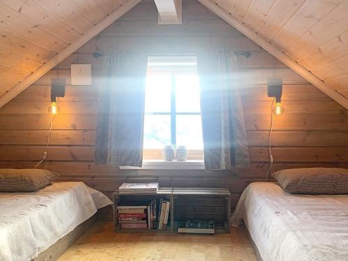 a attic room with two beds and a window at Holiday home Byrkjelo in Byrkjelobrua
