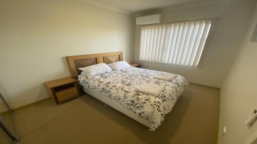 um pequeno quarto com uma cama e uma janela em Unit 58 Seafront Estate em Jurien Bay