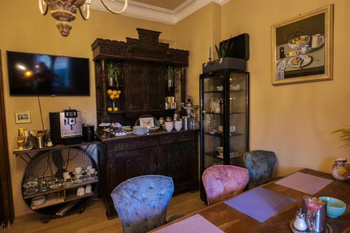 une salle à manger avec une table, des chaises et une armoire dans l'établissement Hotel Villa Glas, à Erlangen