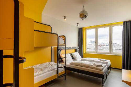 2 łóżka piętrowe w pokoju z oknem w obiekcie MEININGER Hotel Dresden Zentrum w Dreźnie