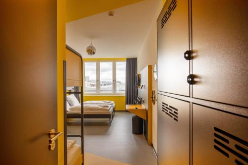 Zimmer mit einem Schlafzimmer mit einem Bett und einem Fenster in der Unterkunft MEININGER Hotel Dresden Zentrum in Dresden