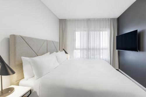 Una televisión o centro de entretenimiento en Meriton Suites Zetland