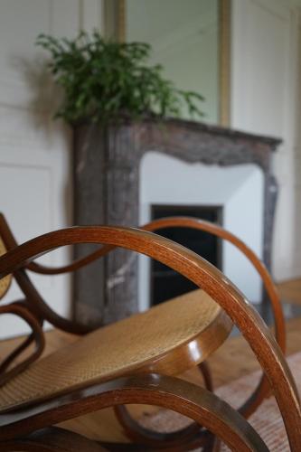 a table and chairs in front of a fireplace at La Villégiature in Coutances