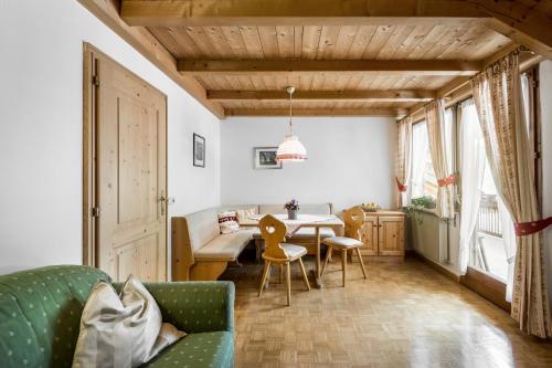 a living room with a green couch and a table at residence Manuela in La Villa