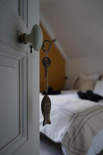 a key hanging from the door of a bedroom at La Villégiature in Coutances