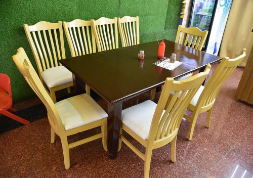 a wooden table and chairs in a restaurant at ASHOKA PALACE in Sawāi Mādhopur